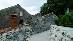 Un bâtiment rustique en pierre, doté d’une porte en bois et d’une petite fenêtre.