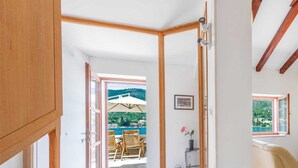 Una habitación con vista a un balcón, una puerta de madera y una escalera.