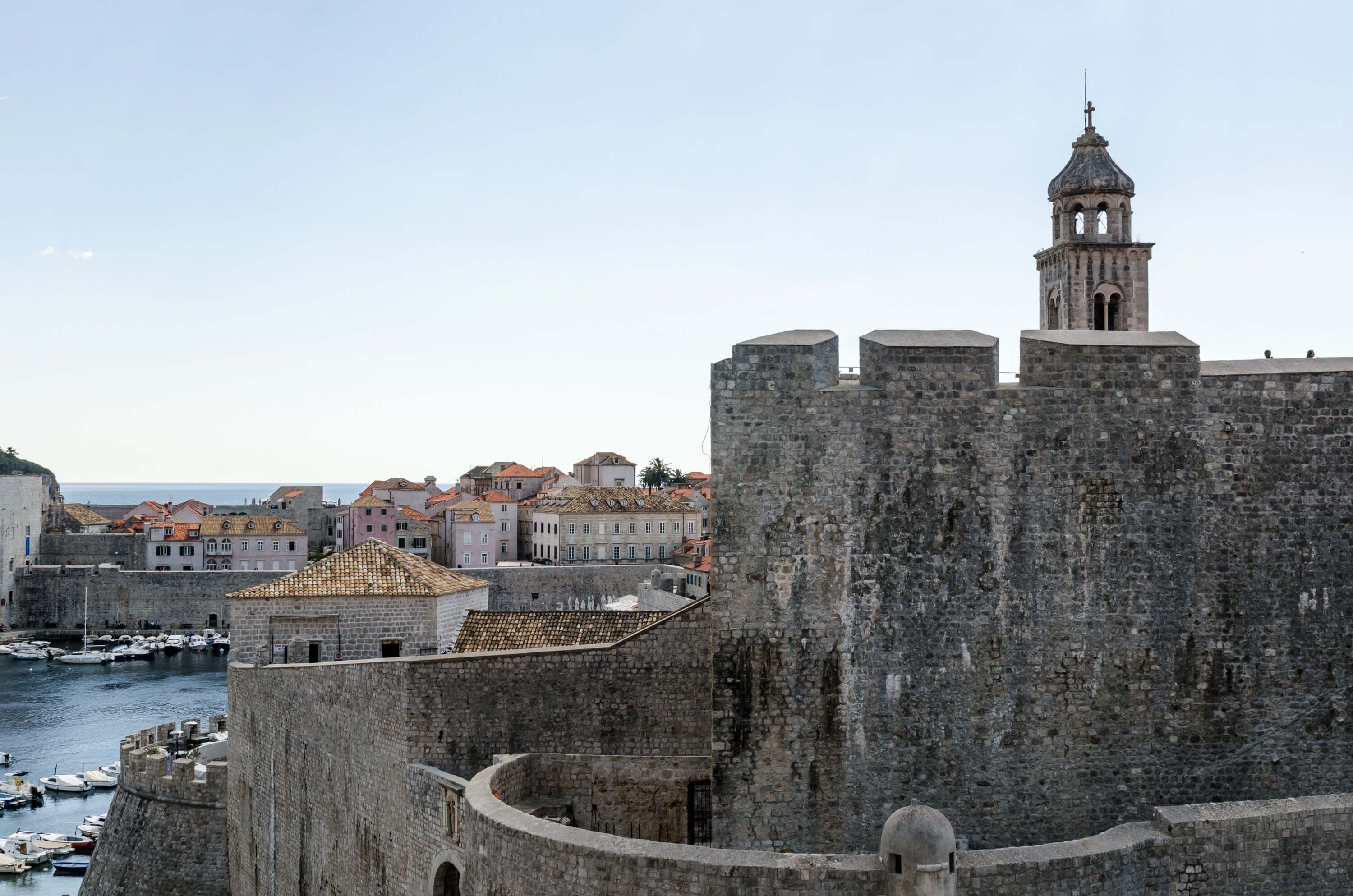 Una fortaleza histórica de piedra con una torre destacada y una campana.
