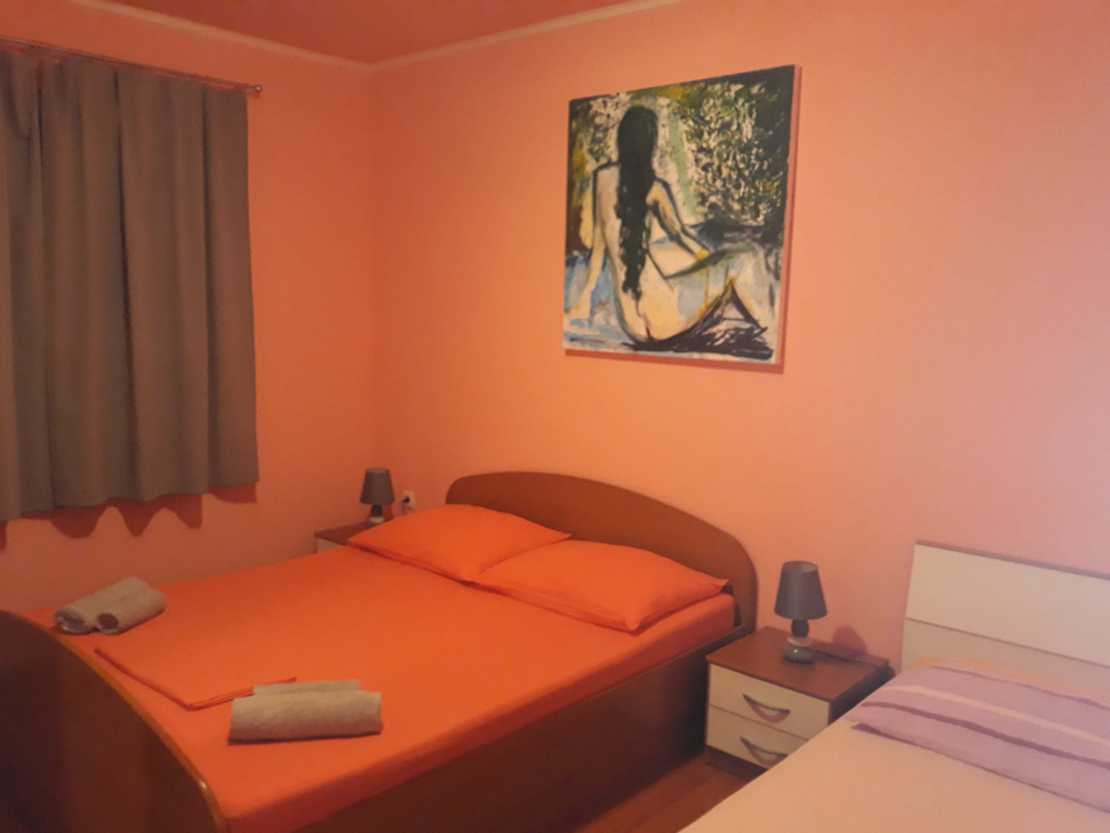 Un dormitorio con una cama individual, una mesita de noche, una lámpara y un cuadro en la pared.