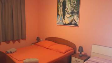 Un dormitorio con una cama individual, una mesita de noche, una lámpara y un cuadro en la pared.