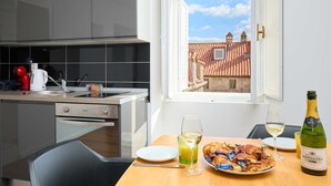 Eine moderne Küche mit Esstisch, gedeckt für ein Frühstück, mit Croissants und einer Flasche Brut-Champagner.