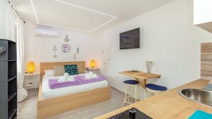 A modern hotel room with a bed, bedside lamps, a TV, a small table, and a sink. - #SEA SHELL bubble jacuzzi (Dubrovnik)