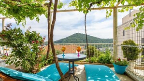 A balcony with a table, chairs, and potted plants. - #SEA SHELL bubble jacuzzi (Dubrovnik)