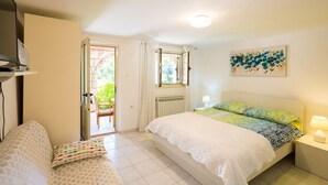 Une chambre à coucher avec un lit, une table de chevet et une fenêtre.