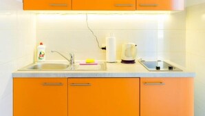 A kitchen with orange cabinets, a white countertop, and a sink. - Perfect Studio on Lapad Peninsula 1 (Dubrovnik)