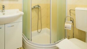 A modern bathroom with a glass-enclosed shower, a white sink, and a toilet. - Perfect Studio on Lapad Peninsula 4 (Dubrovnik)