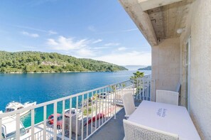 A balcony with a view of a lake and boats, a white table, and a wicker chair. - Dream 2BR apartment4 #Mljet#seaview (Mljet)