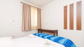 Ein Hotelzimmer mit Bett, Schreibtisch und einem fenster mit Vorhängen.