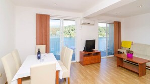 Ein geräumiger Wohnbereich mit Esstisch, Sofa und Fernsehschrank.