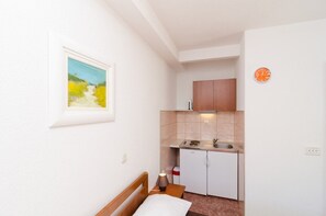 Kjøleskap, kokeplater, kjøkkenutstyr og spisebord