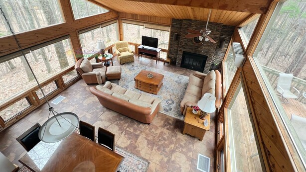 A spacious living room with a fireplace, large windows, and a dining area.