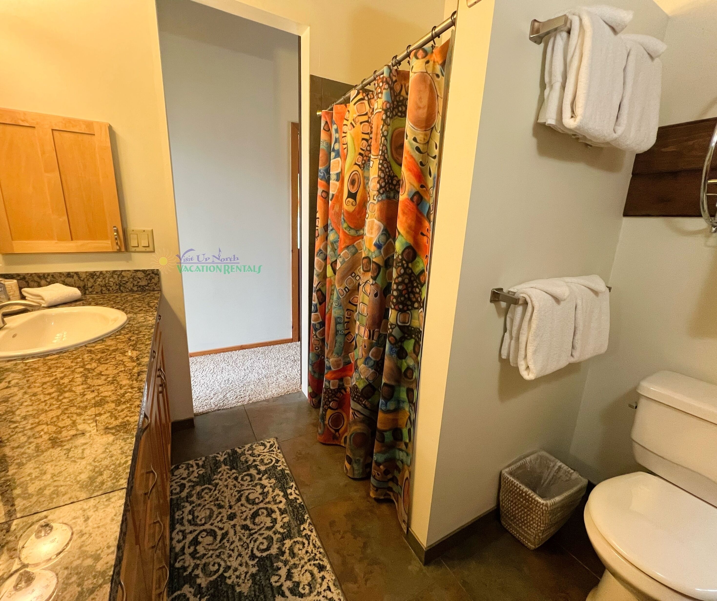 Een badkamer met een wastafel, toilet en douchegordijn.