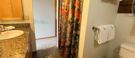 Een badkamer met een wastafel, toilet en douchegordijn.