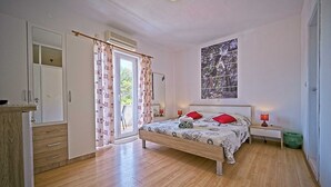 Un dormitorio con cama, ventana con vistas, puerta y armario.