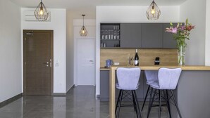 A modern kitchen with a wooden countertop, two bar stools, and pendant lights. - Jasmin Lush TOP FLOOR - one bedroom apartment (Mljet)