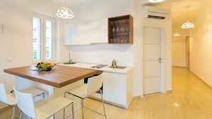A modern kitchen with a wooden island, white cabinetry, and pendant lighting. - Superior suite with sea view :) PRECIOUS MOMENTS (Mljet)
