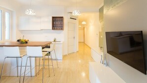 A modern kitchen with white cabinetry, a wooden island, and pendant lighting. - Superior suite with sea view :) PRECIOUS MOMENTS (Mljet)