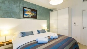 A hotel room with a large bed, a painting on the wall, and a wardrobe. - Superior suite with sea view :) PRECIOUS MOMENTS (Mljet)