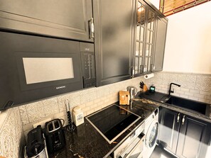A modern kitchen with a built-in oven, a coffee machine, and a washing machine.