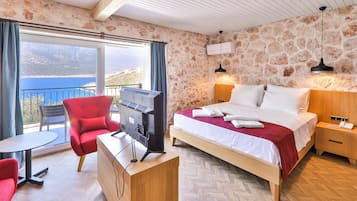 A hotel room with a bed, a TV, a desk, and a chair.
