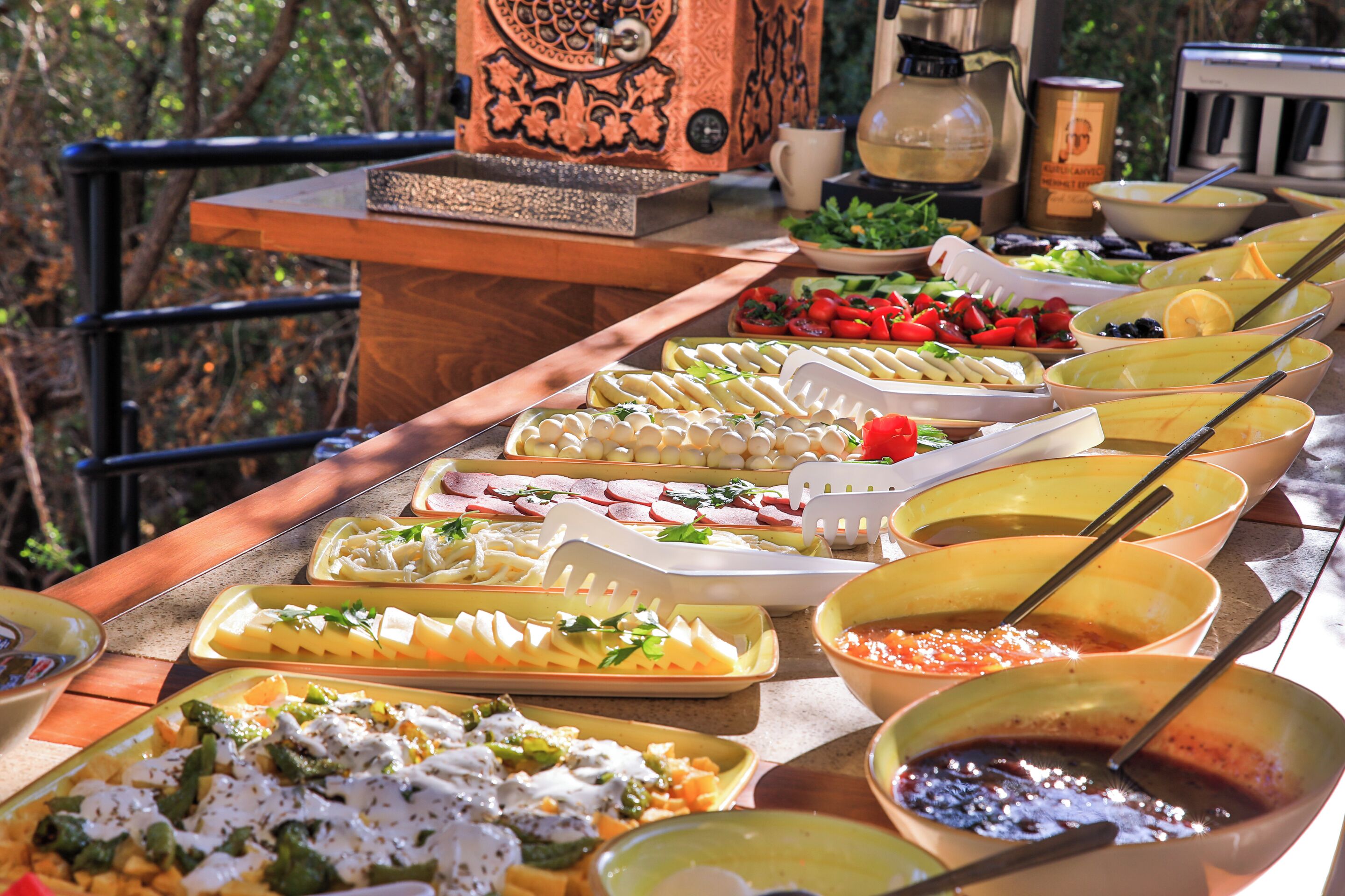 A buffet table with various dishes and a coffee machine.