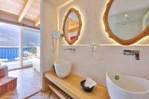 Un baño con un espejo grande, dos lavamanos y un banco de madera.