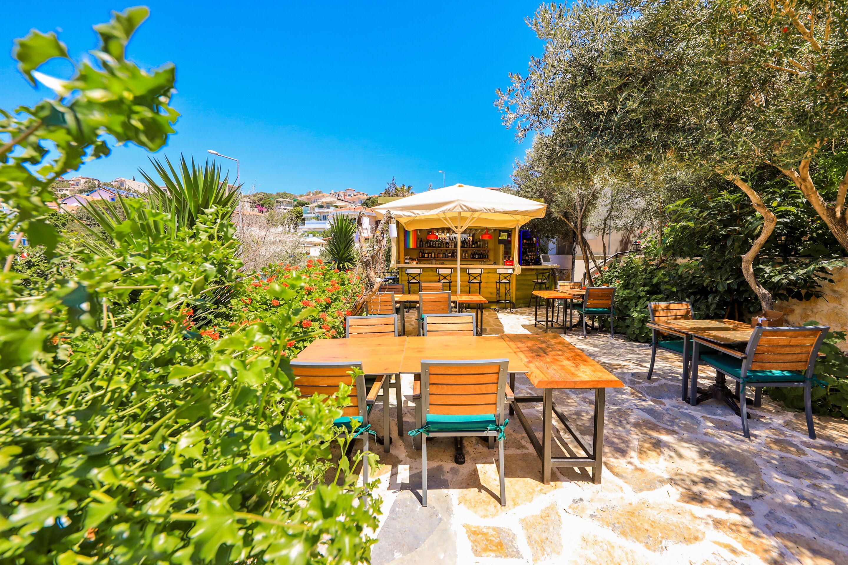 Un'area salotto all'aperto con tavoli e sedie, un bar e vista sul paesaggio circostante.