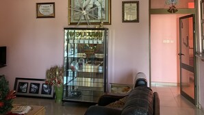 Uma sala de estar moderna com sofá de couro, uma vitrine de vidro e um candelabro.