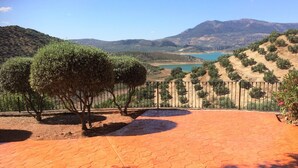 A paved patio with a view of a lake and hills.