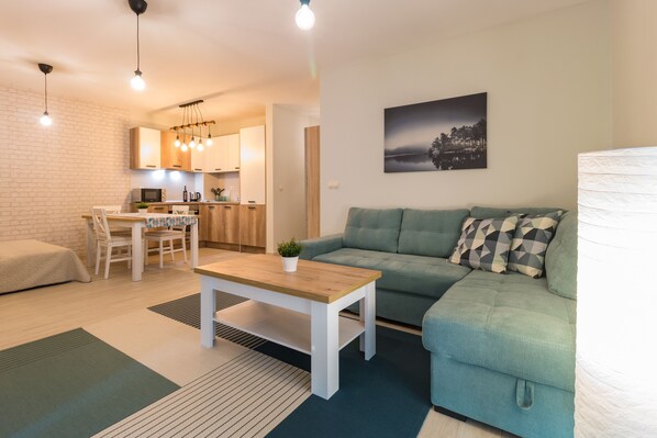 Deluxe-Apartment, Balkon, Stadtblick | Wohnbereich | 50-Zoll-Flachbildfernseher mit Kabelempfang, Fernseher