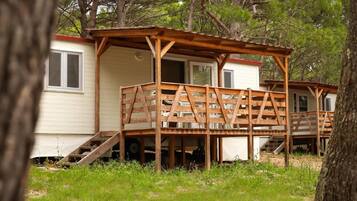 A wooden deck structure attached to a cabin with a ramp leading to the entrance.