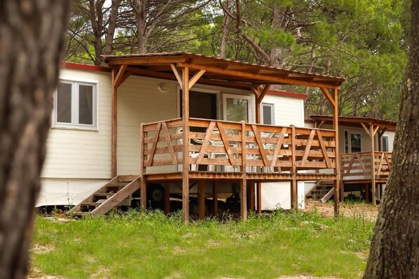 A wooden deck structure attached to a cabin with a ramp leading to the entrance. - Mediteran Travel Mobile Homes Basko Polje (Baska Voda)