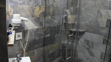 Une salle de bain moderne avec une douche à parois de verre, un lavabo blanc et des toilettes.