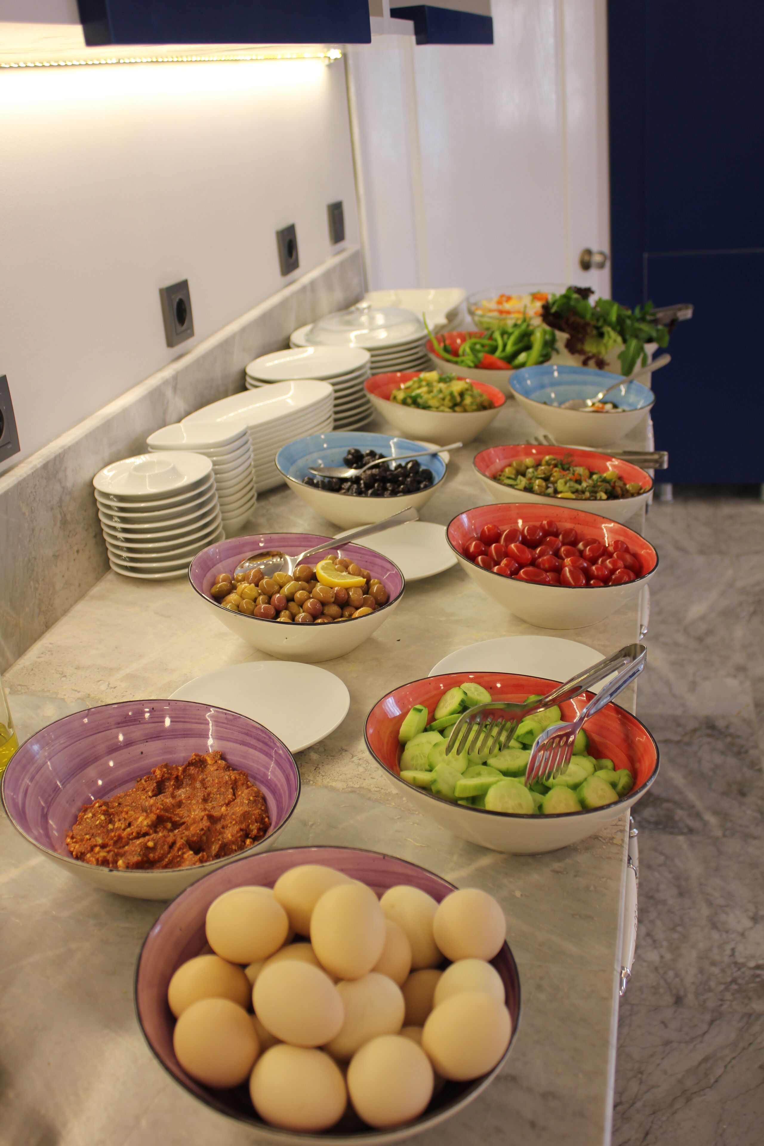 A buffet with various dishes including eggs, beans, and salads.