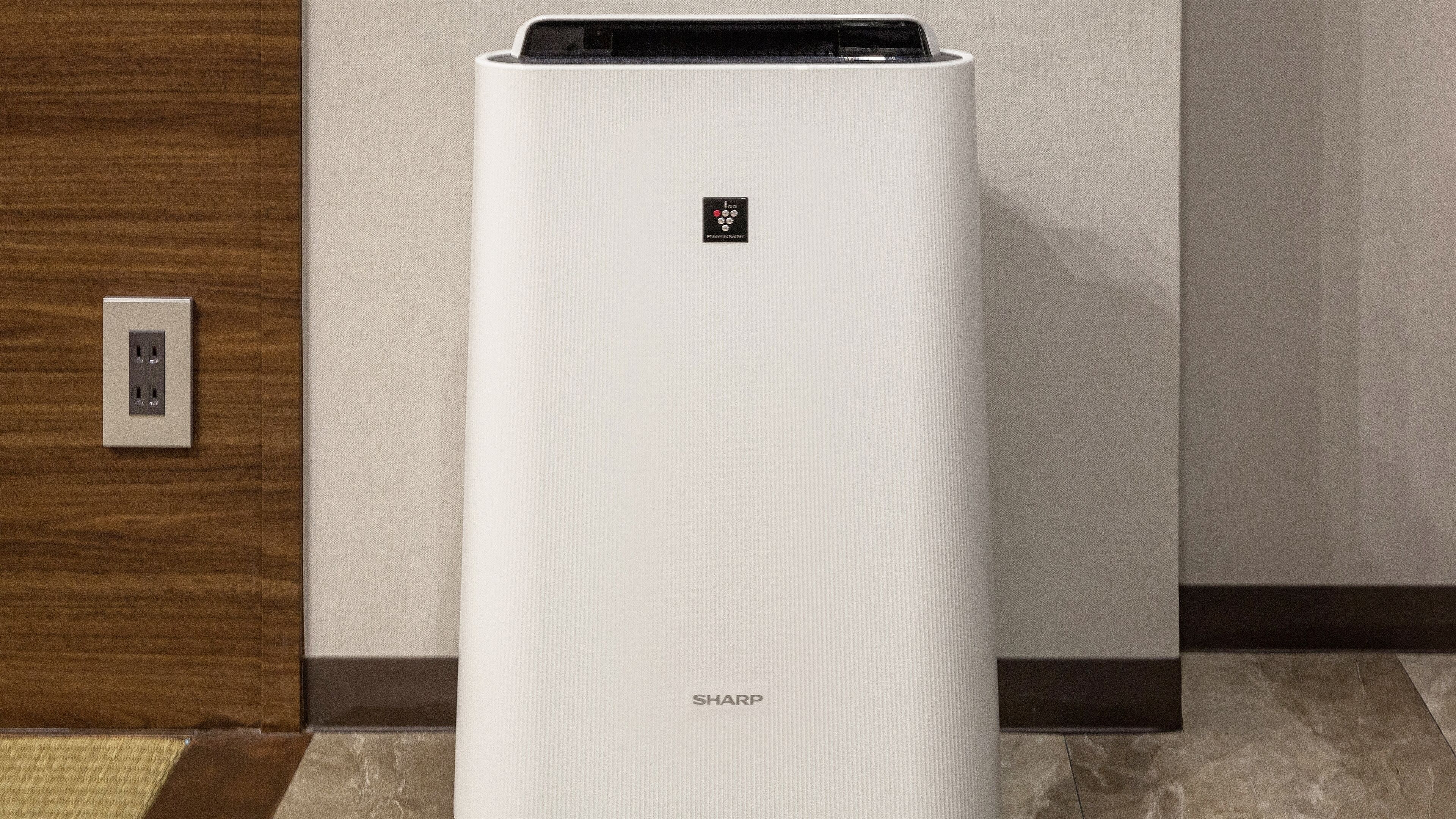 A white air conditioning unit with a control panel and the brand name 'SHARP' on the front.