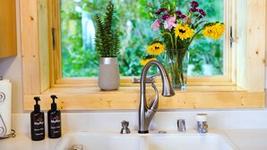 A bathroom with a window, a sink, a faucet, and toiletries. - Nederland Getaway 4 Bedroom Home by RedAwning (Nederland)