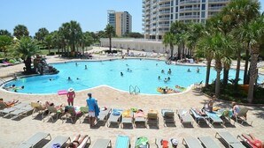 A pool area with multiple swimming pools, lounge chairs, and palm trees. - St. Croix 1406 3 Bedroom Condo by RedAwning (Destin)