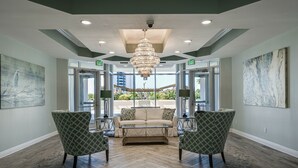 A lobby with a chandelier, a sofa, two armchairs, and a coffee table. - St. Croix 1406 3 Bedroom Condo by RedAwning (Destin)