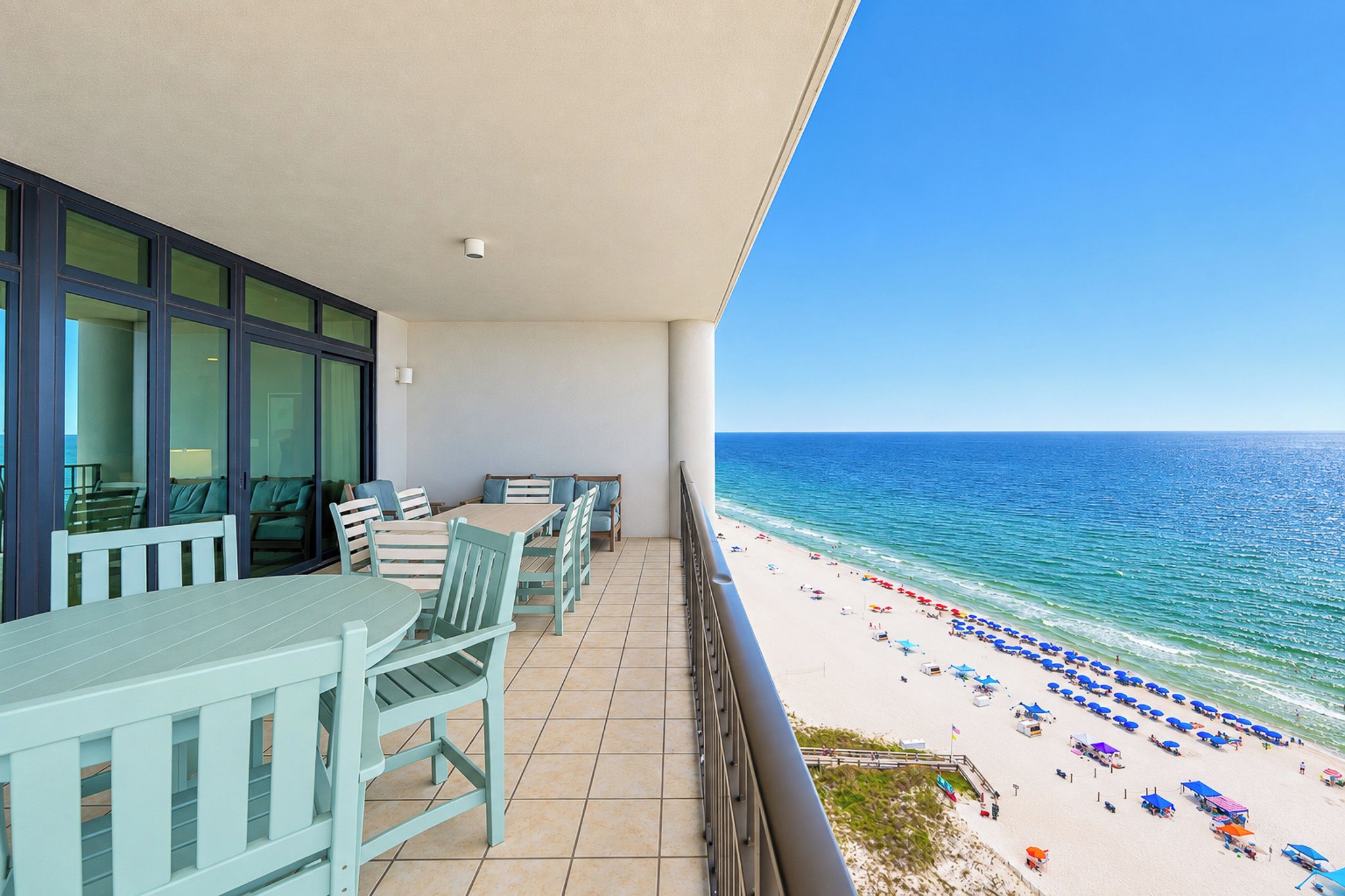 Een balkon met uitzicht op strand en zee.