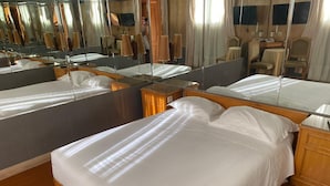 Une chambre d’hôtel avec deux lits, un grand miroir et un plancher en bois.