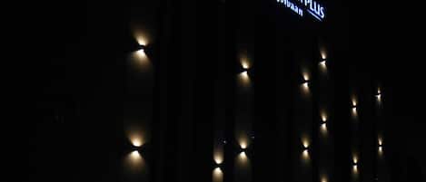 Exterior de un hotel de noche con señalización iluminada que dice "Best Western PLUS Tejuiyaan".