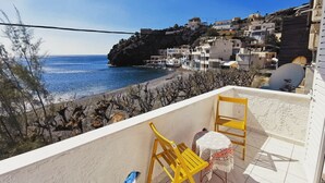 A balcony with a view of the sea and buildings.