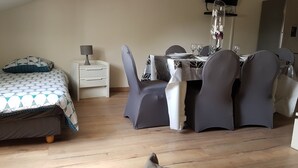 A room with a bed, a small table with chairs, and a lamp.