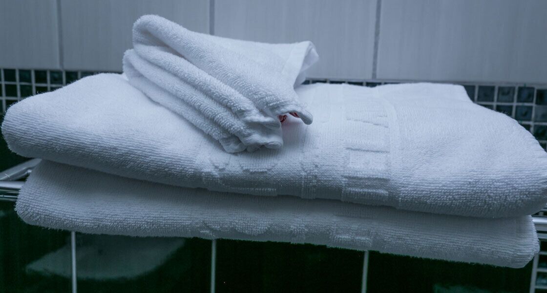 A stack of white towels on a glass surface.