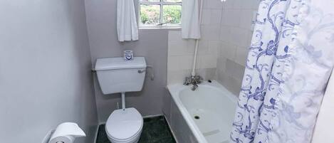 Et badeværelse med toilet, bidet og badekar.