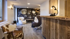 A modern interior with a wooden reception desk, a round mirror, and a seating area with a cowhide chair and a white sofa.