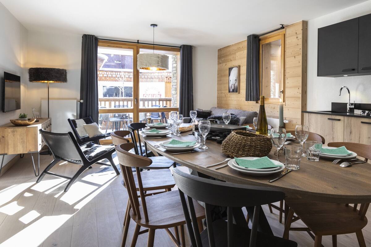 Een eethoek met een houten tafel gedekt voor een maaltijd, omringd door stoelen.