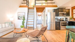Un appartement de style « loft » comprenant une cuisine, un coin repas et un salon.