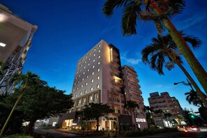 A multi-story hotel with a modern design, featuring balconies on each floor and a well-lit facade. - Y S Inn Naha Oroku Ekimae (Naha)